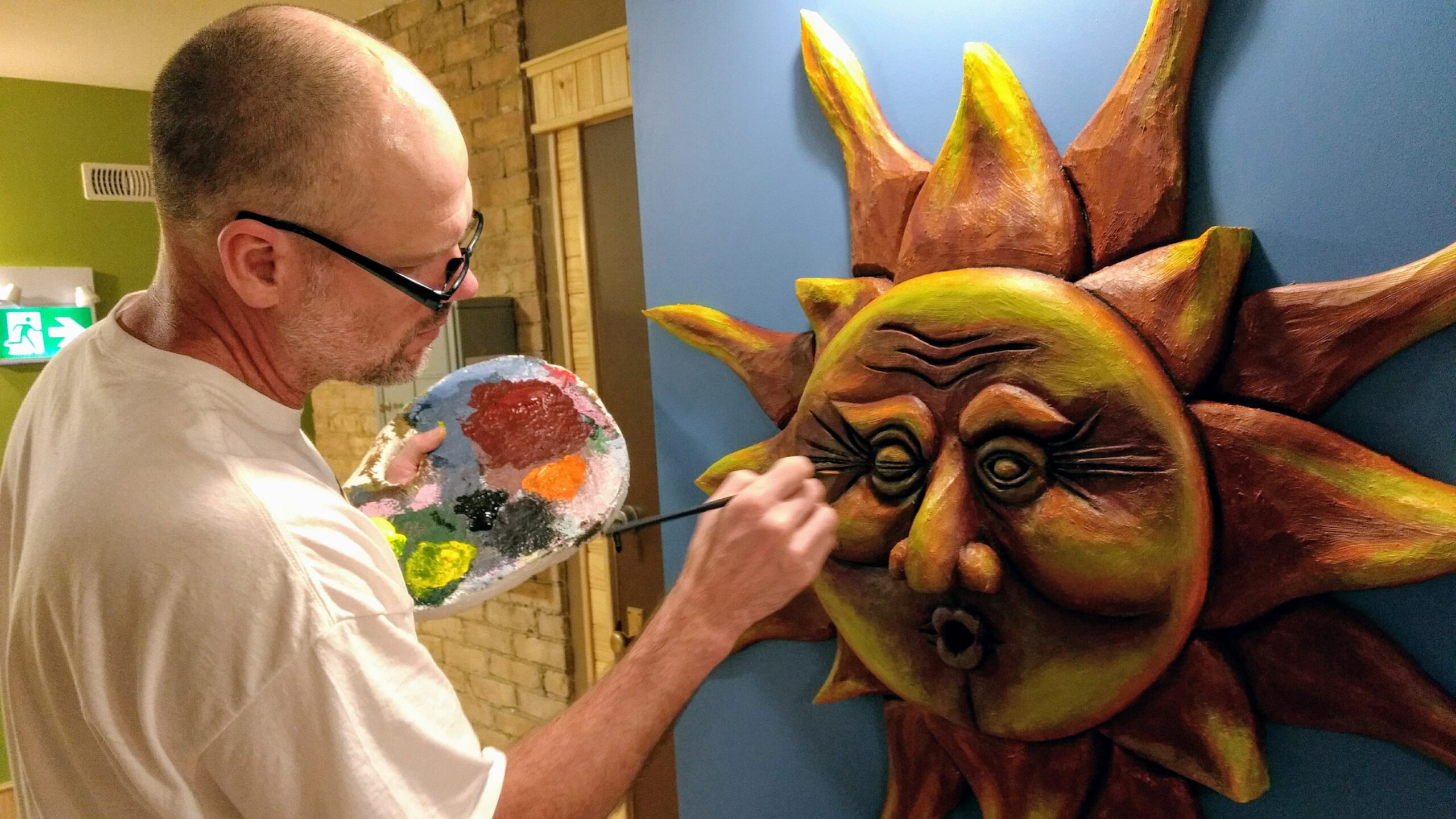 escape-room-old-post-harriston-artist-designer-tony-hale tony hale paints a large sun sculpture on the wall